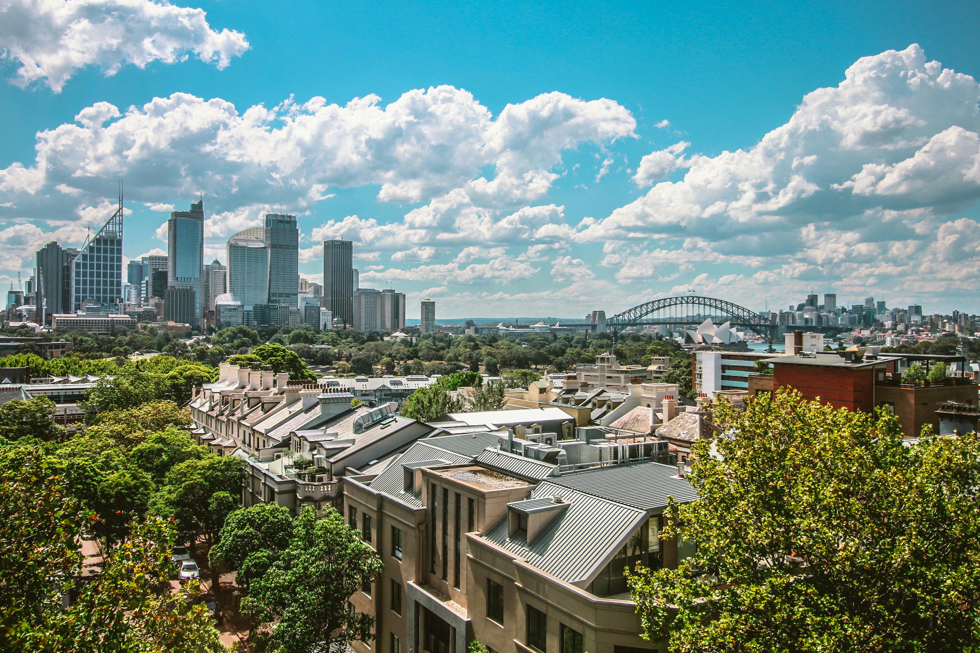 An aerial view of a Sydney suburb. The Sydney Harbour Bridge is visible in the background along with some skyscrapers.